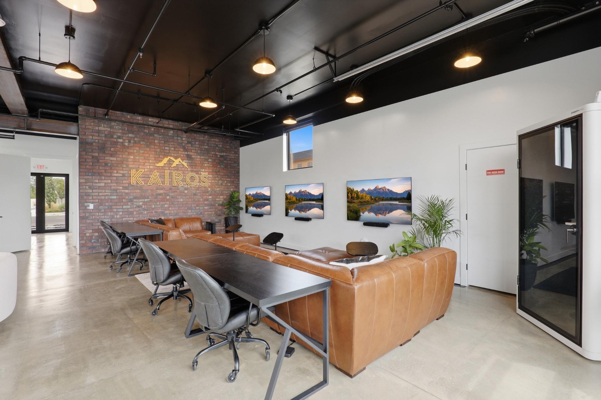 Kairos headquarters lounge with the gold Kairos logo on an exposed brick wall